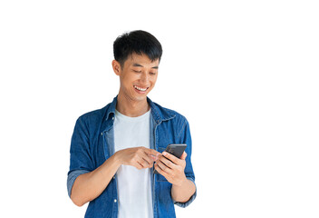 A handsome Asian man wearing a blue jeans shirt is happily playing on a mobile phone isolated on a...