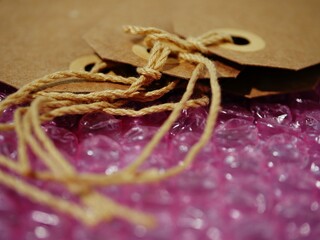 Brown address label gift tag and bubble wrap background close up shot 