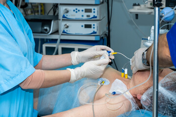 Anesthesiologists administer general anesthesia to a patient on the operating table. Surgery under epidural anesthesia. Doctors administer anesthesia through a system of catheters.