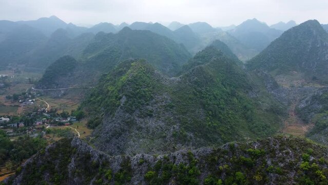 Cool mountain atmosphere over Dong Van Karst Plateau Geopark, Ha Giang. Aerial, parallax