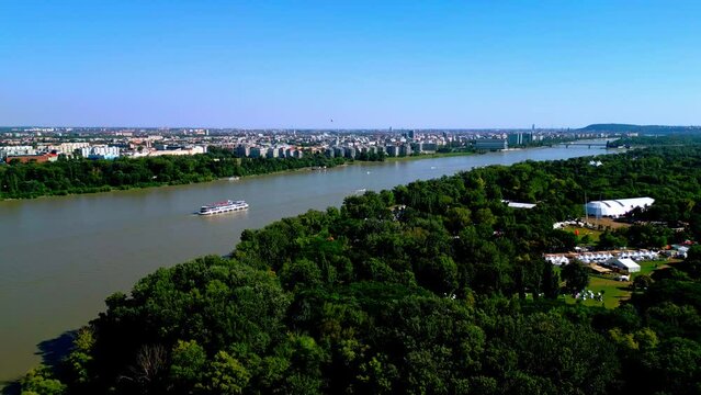 Ship Cruising Tranquil River In Obuda Island, Budapest, Hungary - aerial shot