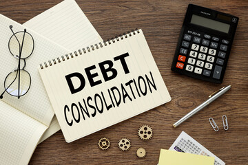 debt consolidation glasses and a calculator lie on a notebook with words