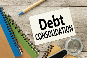 debt consolidation page from notepad with text. magnifier notepad