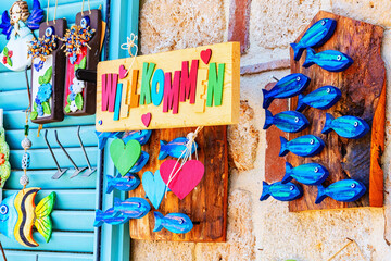 Colorful wall of the gift shop with welcome note, wooden figurines of blue fishes and hearts. Aug 11, 2022. Side, Turkey