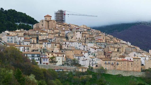 village of Castel del Monte with cranes and construction sites for restoration after earthquake of LAquila