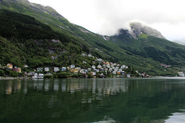 Idyllic view on cloudy fjord Sorfjorden with colorful norwegian residential houses on the hill of...