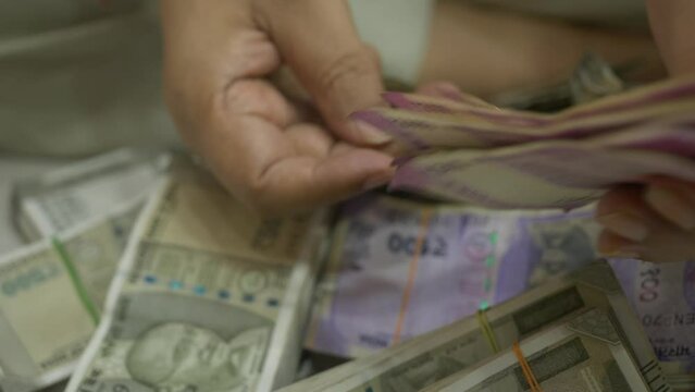 An Indian businessman counting a new series of 2000 Rupee Banknotes, Cash in Hand, Closeup