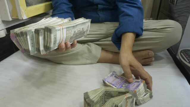 A businessman holding a stack of Indian currency, wealth, Cash in hand, Wide shot
