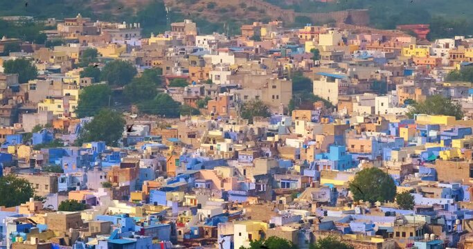 Houses of famous tourist landmark Jodhpur, the Blue City and birds, aerial view from Mehrangarh Fort, Rajasthan, India. Camera zoom out