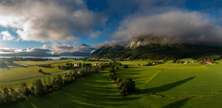 Austria, Upper Austria, Sankt Lorenz, Drone panorama of green fields at foggy sunrise