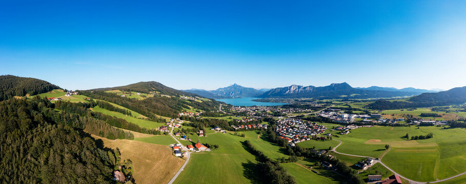Austria, Upper Austria, Mondsee, Drone panorama of lakeshore village and surrounding landscape in summer