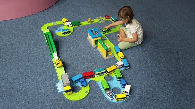 Adorable Little Girl Playing With Toy Cars Moving Bus On Ramp Road Built Highway
