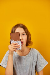 Pretty teen girl with a chocolate bar cover face