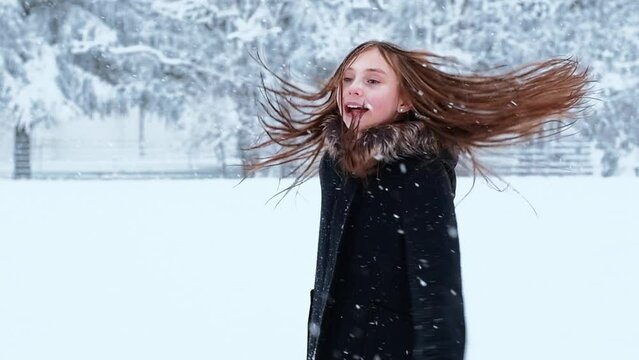 Little cute girl having a fun with a snow in winter cold weather. Winter season joying