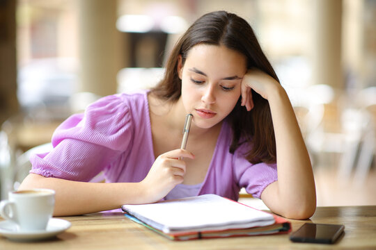 Student memorizing notes in a restaurant terrace
