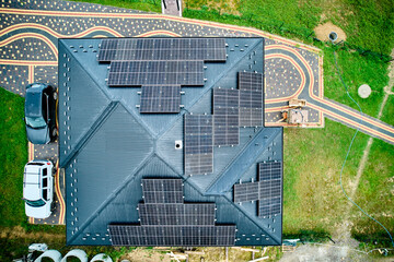 Aerial top view of solar panels on roof. Modern house with alternative electricity source. Concept of green energy.
