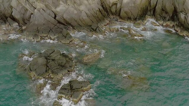 Aerial View of Tranquil Turquoise Waters Embracing Coastal Rocks in Looc, Romblon, Philippines.