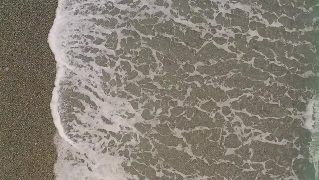 Slow Motion Aerial View of Ocean Waves Along Looc Bay's Coastal Beach with Turquoise Waters, Philippines.