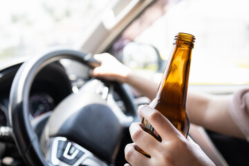 Intoxicated woman driver holding bottle of beer,asian female drinking alcohol while driving motor vehicle,risk or danger of road accidents,Campaign against drunk driving,Don't drink and drive concept - obrazy, fototapety, plakaty