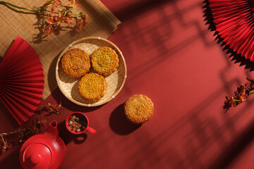 Chinese Mid-Autumn Festival concept made from mooncakes, set of tea and beautiful flower branches...