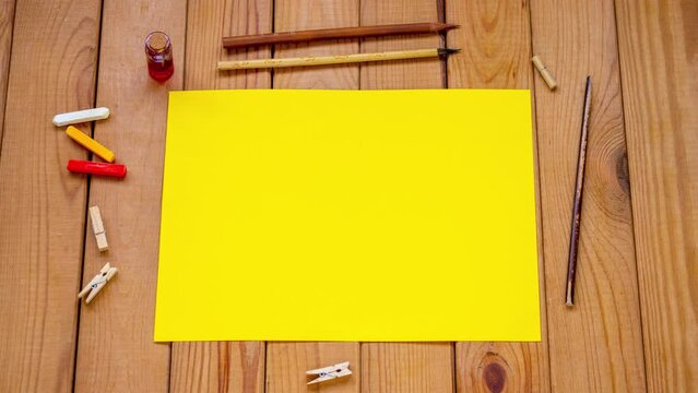 yellow paper on wooden background, stop motion