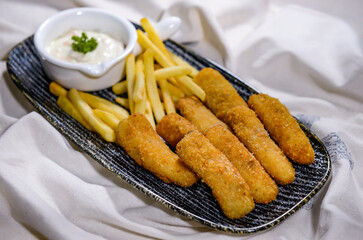 Fried Hamour finger fish with chips and dip served in dish isolated on food table top view of middle east spices