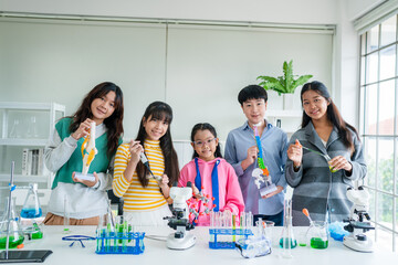 Group of young asian schoolgirls learning research and doing experiment in chemistry classroom. Fun...