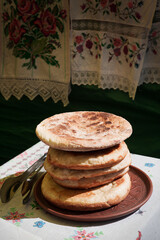 Palyanytsya fragrant Ukrainian bread. Traditional Ukrainian flatbreads in a clay plate on the table.