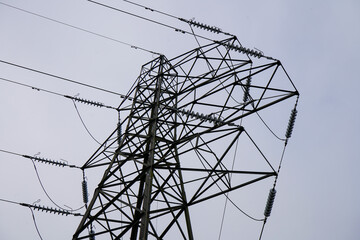 Looking up at a power pylon with overcast sky