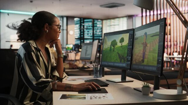 Female Black Game Developer Using Desktop Computer, Designing Unique World And Characters In 3D modelling Software For Survival Video Game. African Woman Working In Diverse Game Design Studio Office.
