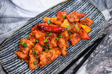 peking style chilli chicken with spring onion and tomato served in dish isolated on food table top...