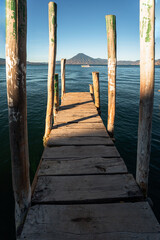 Wooden dock on Lake Atitlan on the beach in Panajachel, Guatemala. With Toliman and San Pedro volcanoes in the background