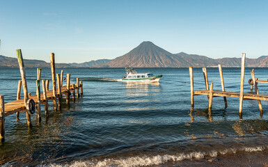 Wooden docks on Lake Atitlan on the beach in Panajachel, Guatemala. With Toliman and San Pedro volcanoes in the background - 649213959