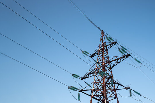 Power line support with wires for electricity transmission. High voltage grid tower with wire cable at distribution station. Energy industry, energy saving.