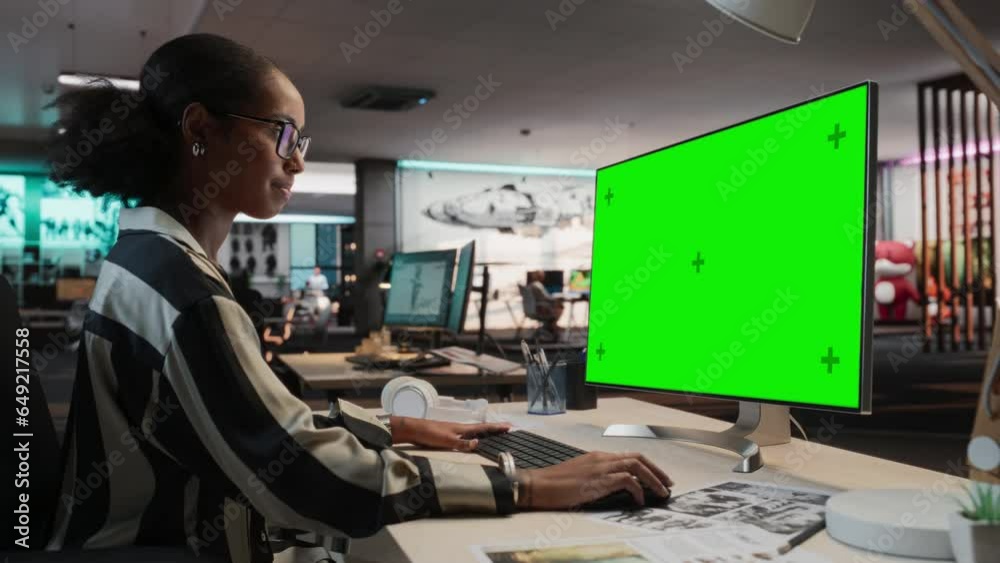 Poster Creative Black Woman Using Desktop Computer with Mock-up Green Screen Chromakey. Female Concept Artist Working in Game Design Startup, Creating Immersive Gameplay For New Survival Video Game.