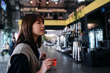 Asian woman waiting at the counter to pay by card