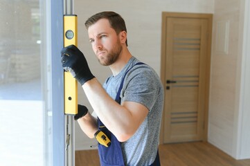 The worker installing and checking window in the house. Concept of new modular houses.