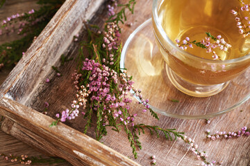 Obraz na płótnie Canvas Heather or calluna vulgaris flowers with a cup of herbal tea