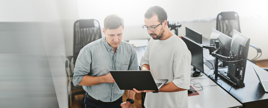 Portrait of two professional male programmers working on computer in diverse offices. Modern IT technologies, development of artificial intelligence, programs, applications and video games concept