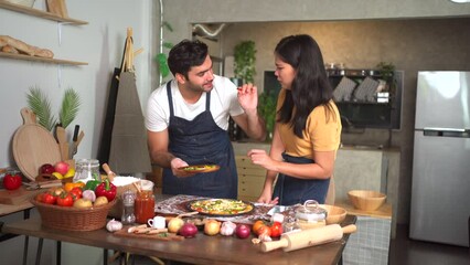 Happy diverse ethnicity couple enjoy breaking pizza together at home. - Powered by Adobe