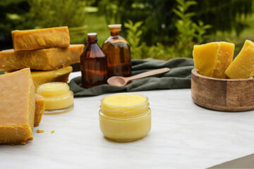 Beeswax ointment, opropolis, wax and essential oils - ingredients for preparing a homemade skin cream. 
Handmade organic lip balm cream. Side view.