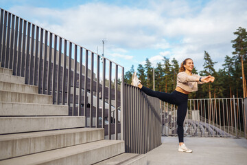 An active woman in sportswear does a stretching exercise, looks at a fitness application through a Smartwatch. Concept for sport, training or active lifestyle.