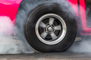 Close up car wheel with smoke on the asphalt road speed track, Car wheel drifting and smoking on track, Car wheel spinning.