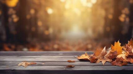 Fallen dry orange leaves on wooden boards against the backdrop of a blurry autumn park.