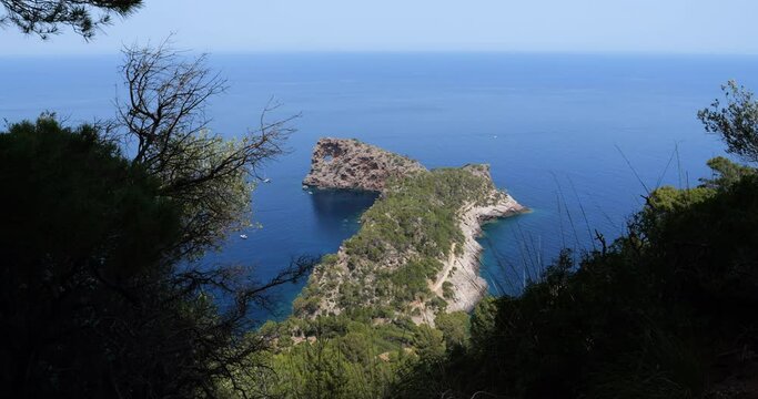 Overhead view of the Sa Foradada peninsula in Sierra de Tramuntana, Mallorca, reveals its iconic iconic hole, a prominent geological feature in the territory of the municipality of Deya.