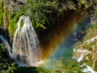 Fototapeta na wymiar Summer view of water lakes and beautiful waterfalls in Plitvice Lakes National Park, Croatia rainbow coming from splashes and drops.