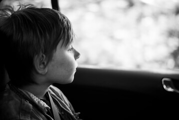 black and white portrait of a 9 year old boy in a car