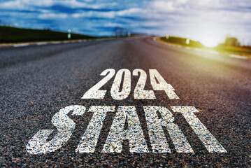 New year 2024 concept. Text 2024 written on the road in the middle of asphalt road with at sunset. Concept of planning, goal, challenge, new year resolution.Toned.