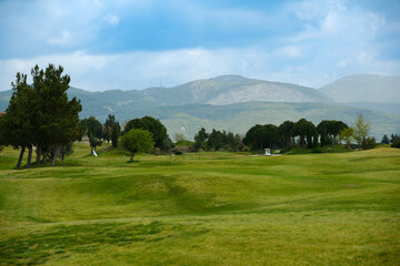 Fototapeta na wymiar Green golf course in front of the mountains, Kusadasi Turkey.