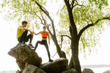 Young woman and man climbing on rocks